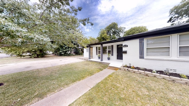 ranch-style home featuring a front lawn and covered porch