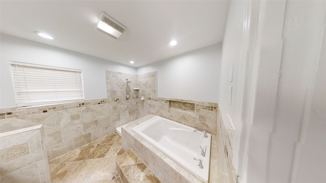 bathroom with tiled bath and tile walls