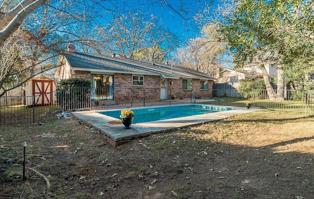 view of swimming pool with a storage unit, a patio area, and a lawn