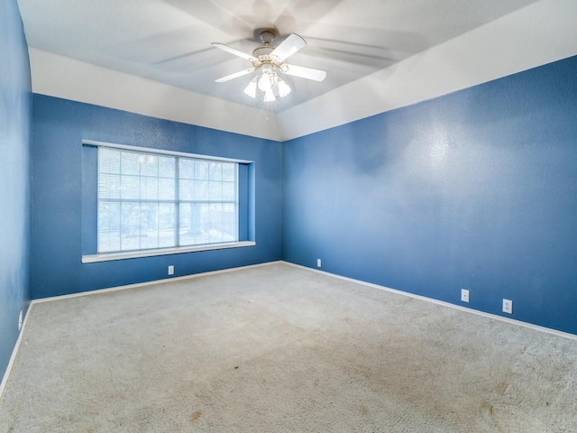 empty room with ceiling fan, carpet floors, and vaulted ceiling