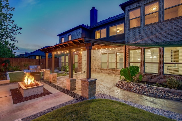 back house at dusk with a patio, a pergola, and an outdoor fire pit