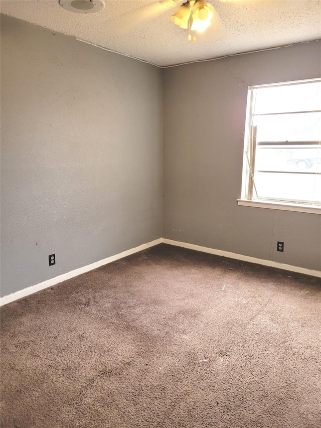 carpeted spare room with ceiling fan and a textured ceiling