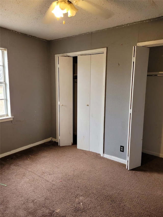 unfurnished bedroom with carpet, a textured ceiling, and ceiling fan