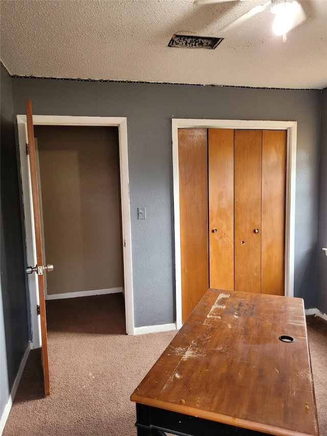 unfurnished office with carpet flooring and a textured ceiling