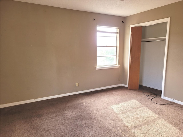 unfurnished bedroom with carpet flooring, a textured ceiling, and a closet