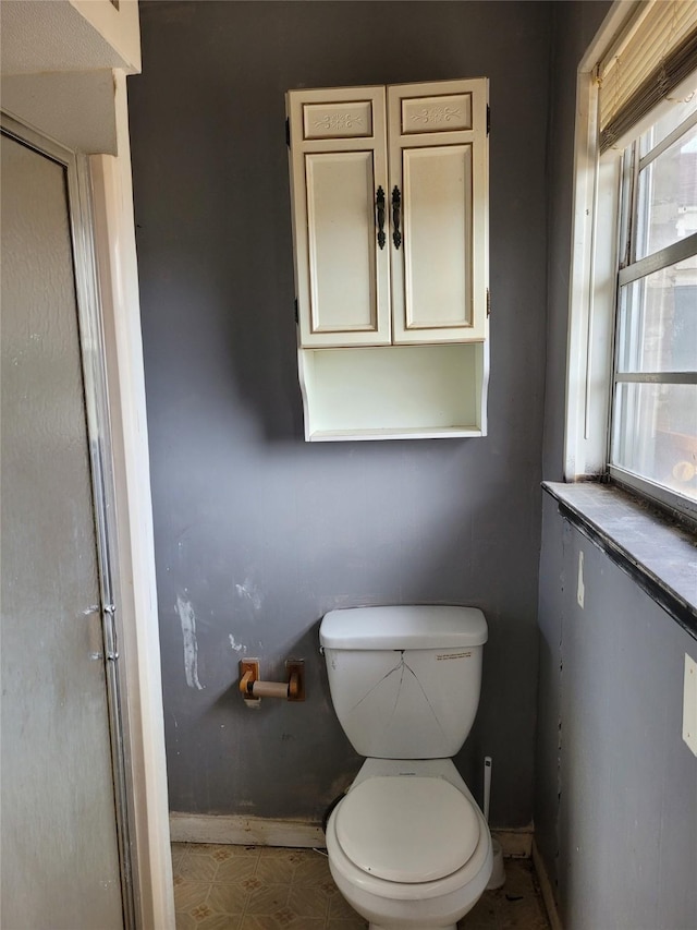 bathroom with plenty of natural light and toilet