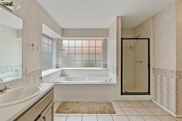 bathroom featuring vanity, separate shower and tub, tile patterned floors, and a textured ceiling