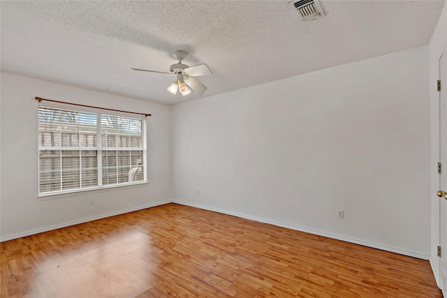 empty room with ceiling fan, a textured ceiling, and light hardwood / wood-style floors