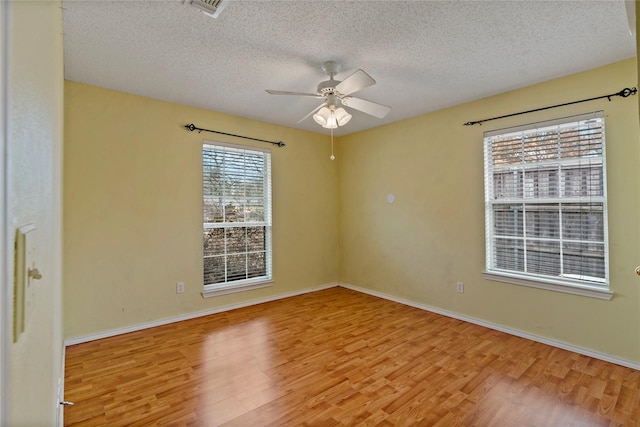 spare room with ceiling fan, a textured ceiling, and light wood-type flooring