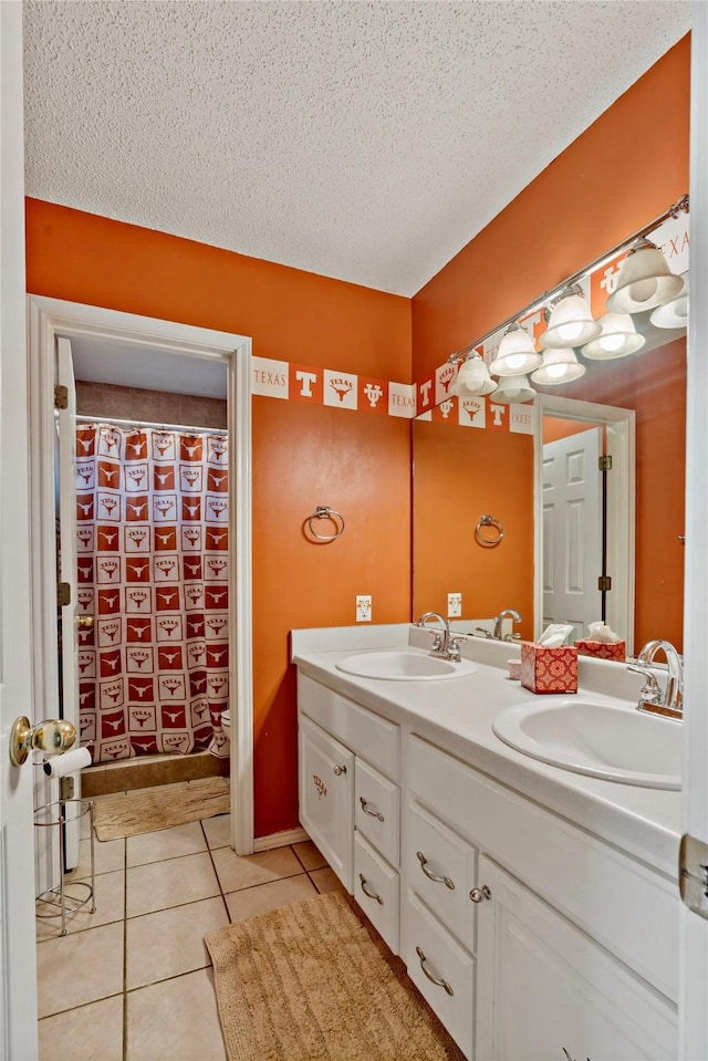 bathroom with tile patterned flooring, vanity, and a textured ceiling