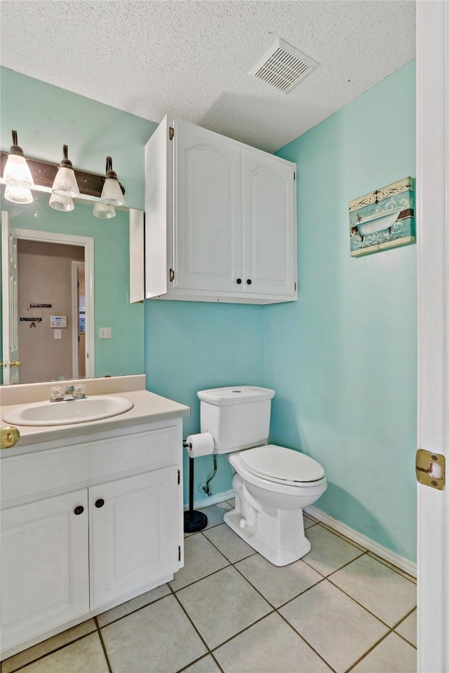 bathroom featuring vanity, a textured ceiling, tile patterned floors, and toilet