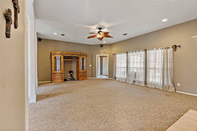 unfurnished living room featuring ceiling fan and light colored carpet