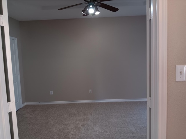 unfurnished room with ceiling fan and dark colored carpet