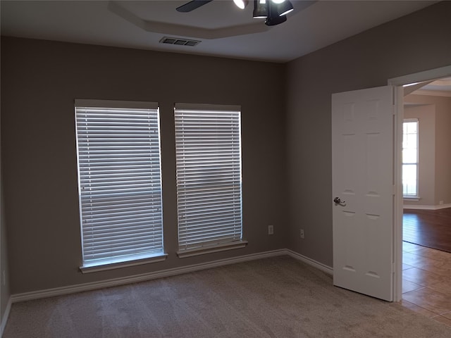 carpeted spare room featuring ceiling fan