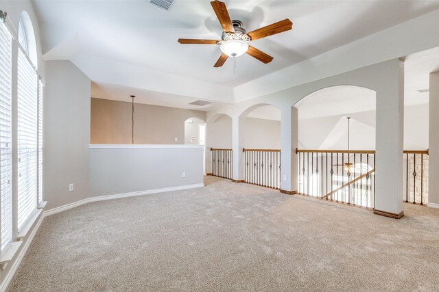 spare room featuring baseboards, plenty of natural light, a ceiling fan, and light colored carpet