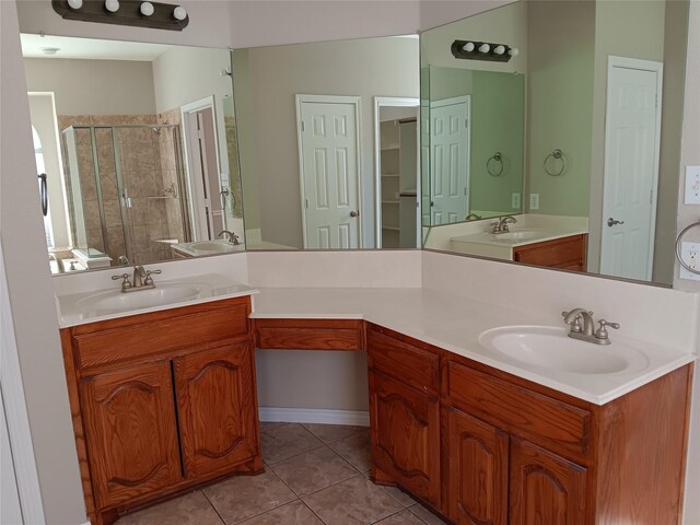 bathroom featuring tile patterned flooring, vanity, and a shower with door