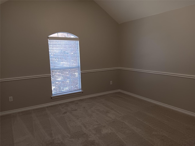 unfurnished room featuring lofted ceiling and carpet flooring