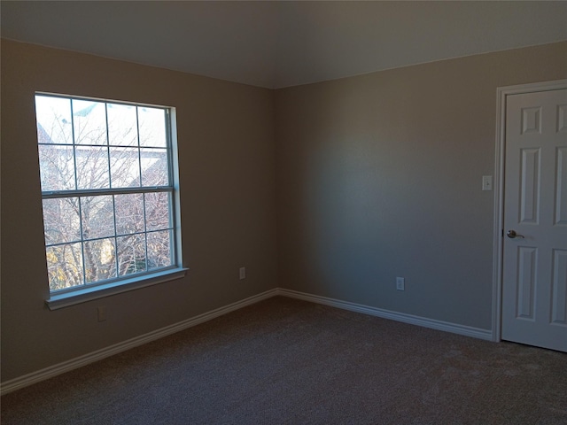 spare room with dark carpet