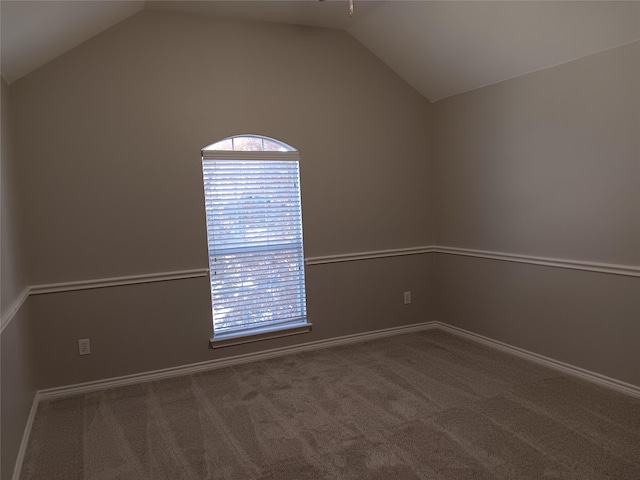 unfurnished room with carpet and vaulted ceiling