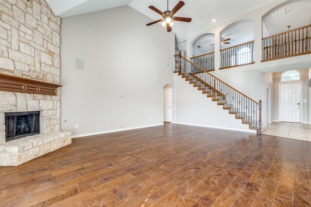 interior space with a chandelier, arched walkways, a tray ceiling, dark wood finished floors, and baseboards