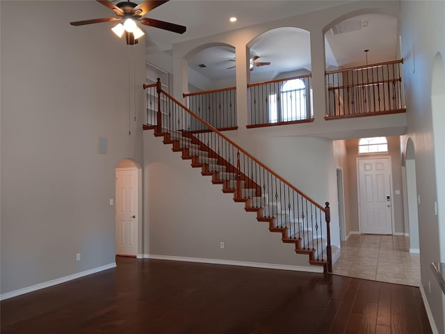 foyer entrance with hardwood / wood-style floors, a towering ceiling, and ceiling fan