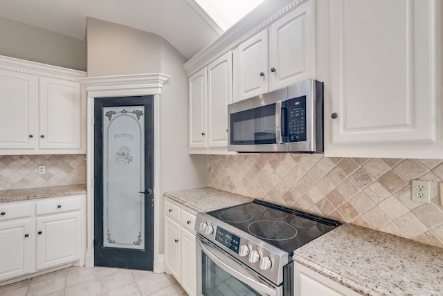 kitchen featuring white cabinets, appliances with stainless steel finishes, and light stone counters