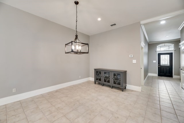 foyer featuring a chandelier, light tile patterned floors, and ornamental molding