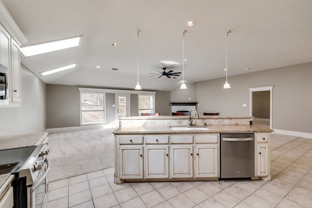 kitchen featuring sink, pendant lighting, light carpet, a center island with sink, and appliances with stainless steel finishes