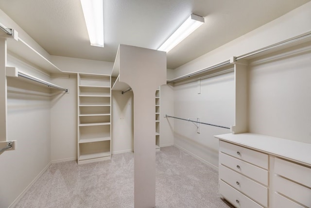 walk in closet featuring light carpet