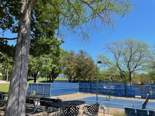 view of tennis court featuring basketball hoop