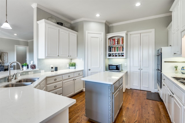 kitchen featuring a center island, sink, decorative light fixtures, decorative backsplash, and white cabinets