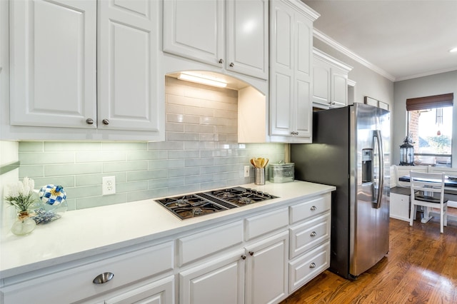 kitchen featuring white cabinets, crown molding, tasteful backsplash, dark hardwood / wood-style flooring, and stainless steel appliances