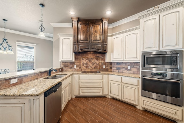 119 Remington Park Dr, Springtown, TX 76082 - kitchen with dark wood finished floors, appliances with stainless steel finishes, a sink, decorative light fixtures, and cream cabinets