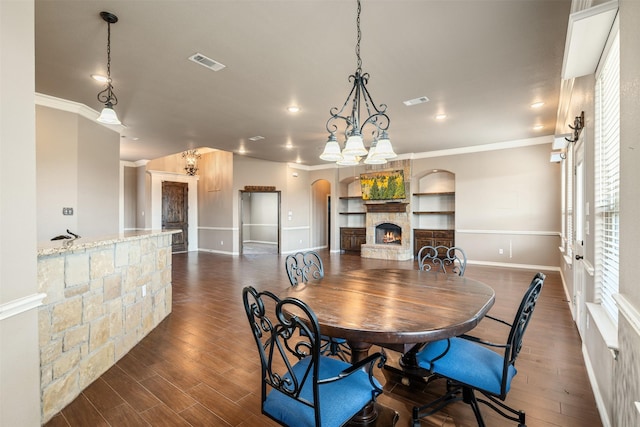119 Remington Park Dr, Springtown, TX 76082 - dining room featuring ornamental molding, dark wood-style floors, a fireplace, and visible vents