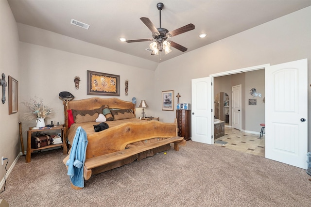 bedroom featuring light carpet, ensuite bath, vaulted ceiling, and ceiling fan