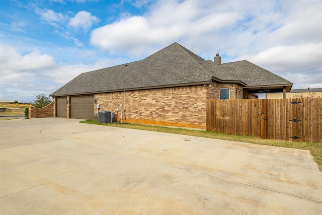 view of side of property with central AC and a garage