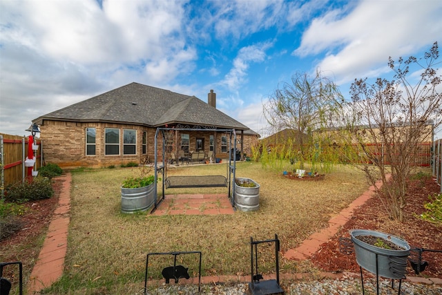 119 Remington Park Dr, Springtown, TX 76082 - back of property with a fenced backyard, brick siding, a lawn, and a patio