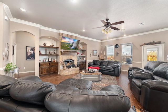 living room featuring a fireplace, hardwood / wood-style flooring, built in features, and plenty of natural light