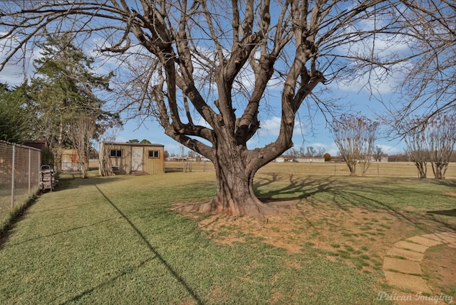 view of yard featuring a rural view and a storage shed