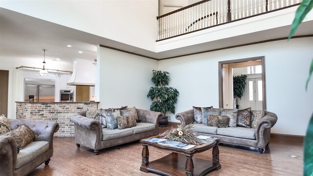 living area with a tiled fireplace, built in features, light colored carpet, and ornamental molding