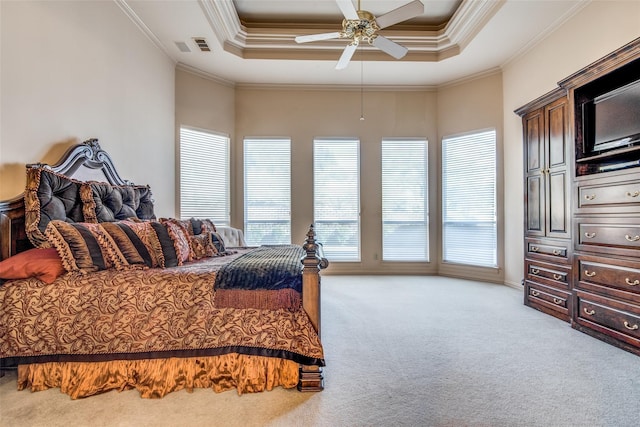 carpeted bedroom featuring a raised ceiling, ceiling fan, and crown molding