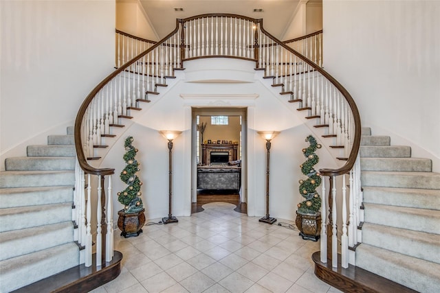 staircase with tile patterned flooring and a high ceiling