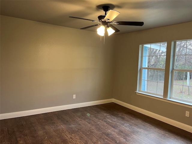 empty room with ceiling fan and dark hardwood / wood-style flooring