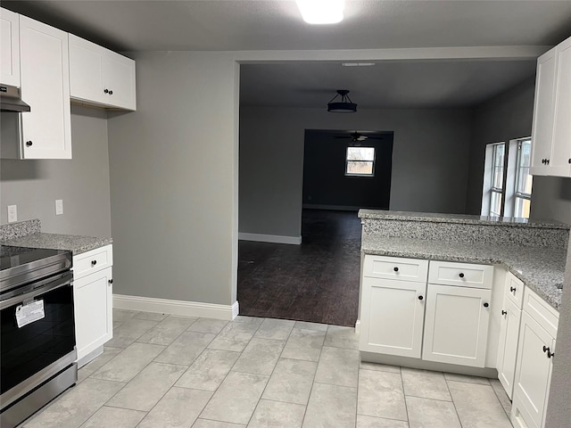 kitchen with white cabinets, electric range, light stone counters, and ceiling fan