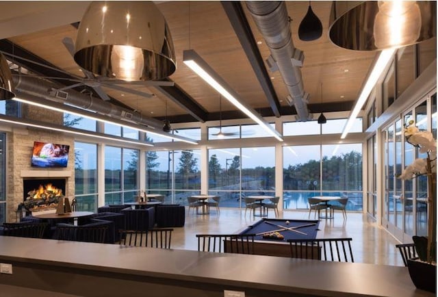 interior space featuring a large fireplace, expansive windows, and pool table