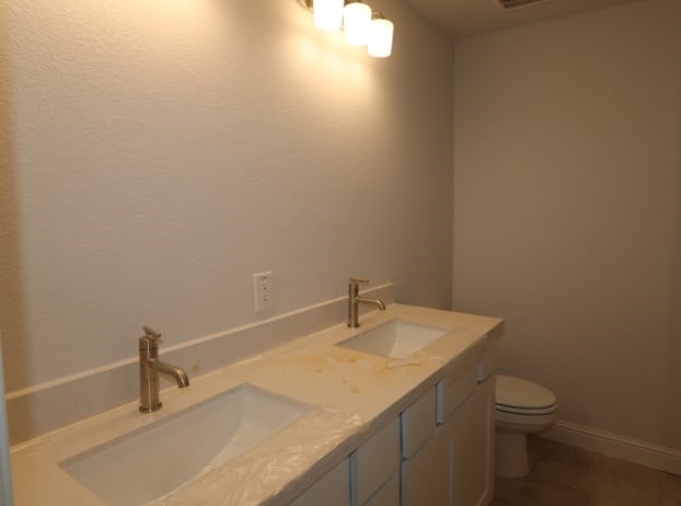 bathroom featuring tile patterned floors, vanity, and toilet