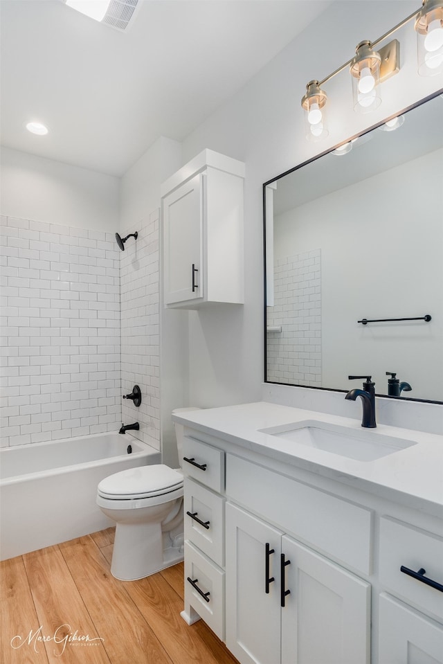 full bathroom featuring vanity, toilet, and tiled shower / bath combo