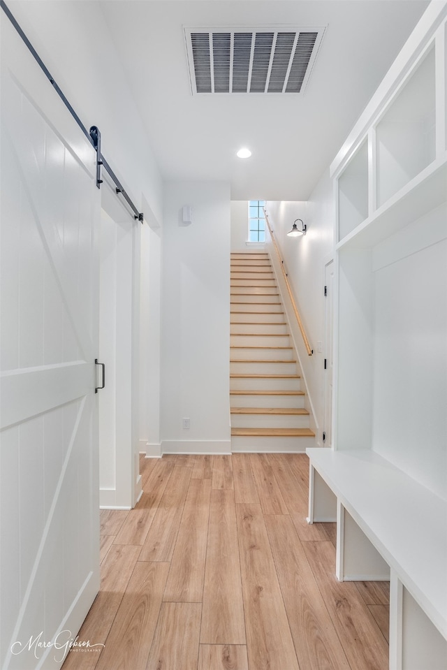 mudroom featuring light hardwood / wood-style floors and a barn door