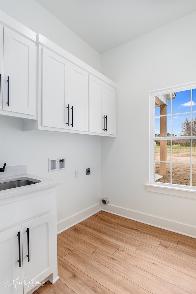 laundry room with sink, cabinets, washer hookup, light hardwood / wood-style floors, and electric dryer hookup