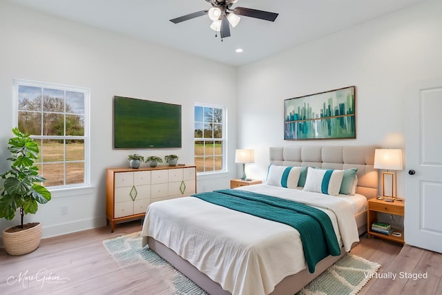 bedroom with multiple windows, ceiling fan, and light wood-type flooring